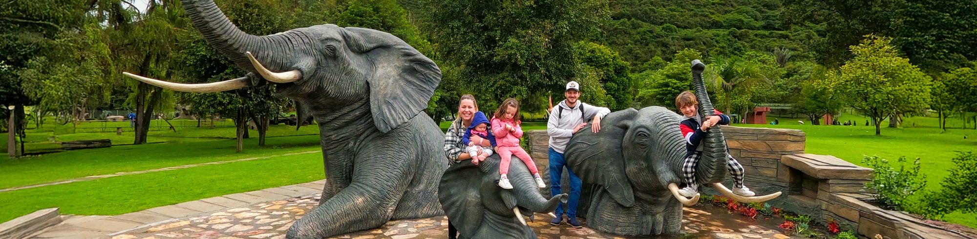 Familia sonriendo en la atracción de elefantes del Parque Jaime Duque